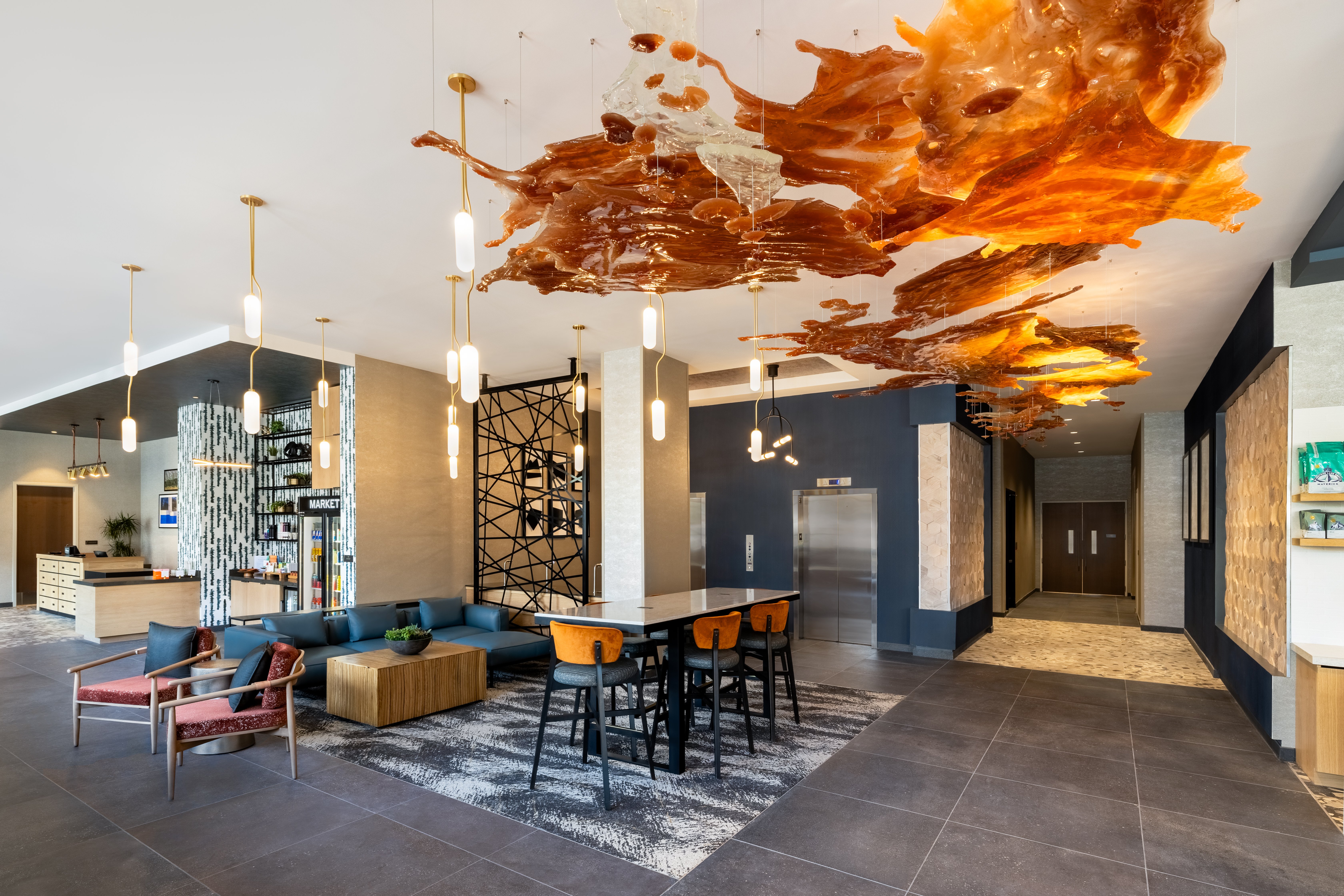 yellow and orange interior decoration inside of a hotel lobby with gray carpet